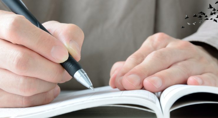 ノートにペンで文字を書き込む手元のアップ｜勉強や仕事のメモを取る学習記録イメージ