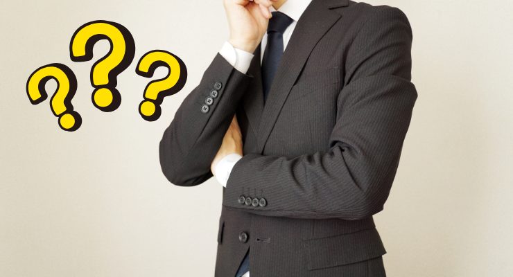 スーツ姿の男性が考え込む様子｜転職やキャリア選択に悩むビジネスパーソンのイメージ